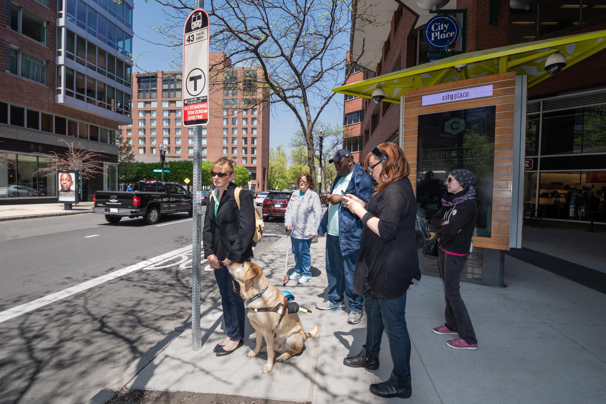 customers waiting at bus stop with guide dog