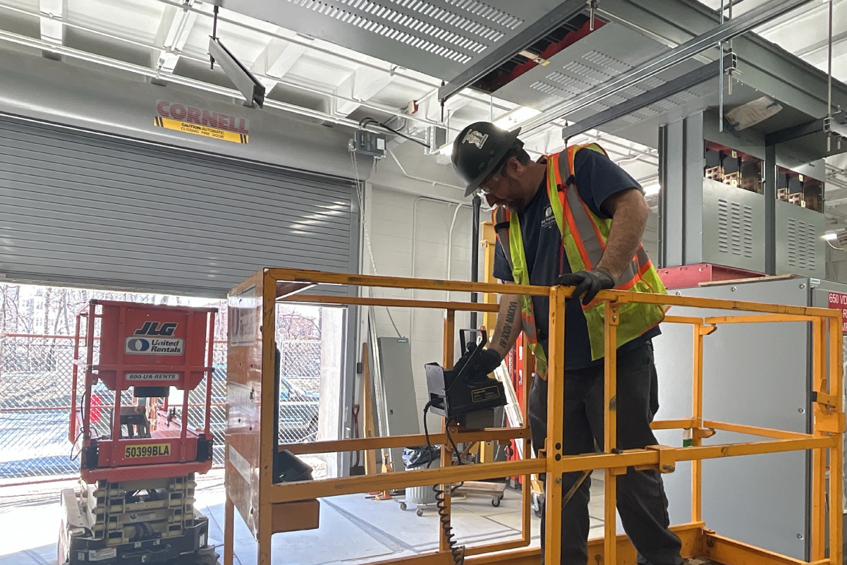 crew member operating a lift while standing in it